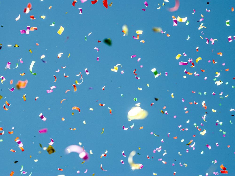 Colorful confetti against a blue sky