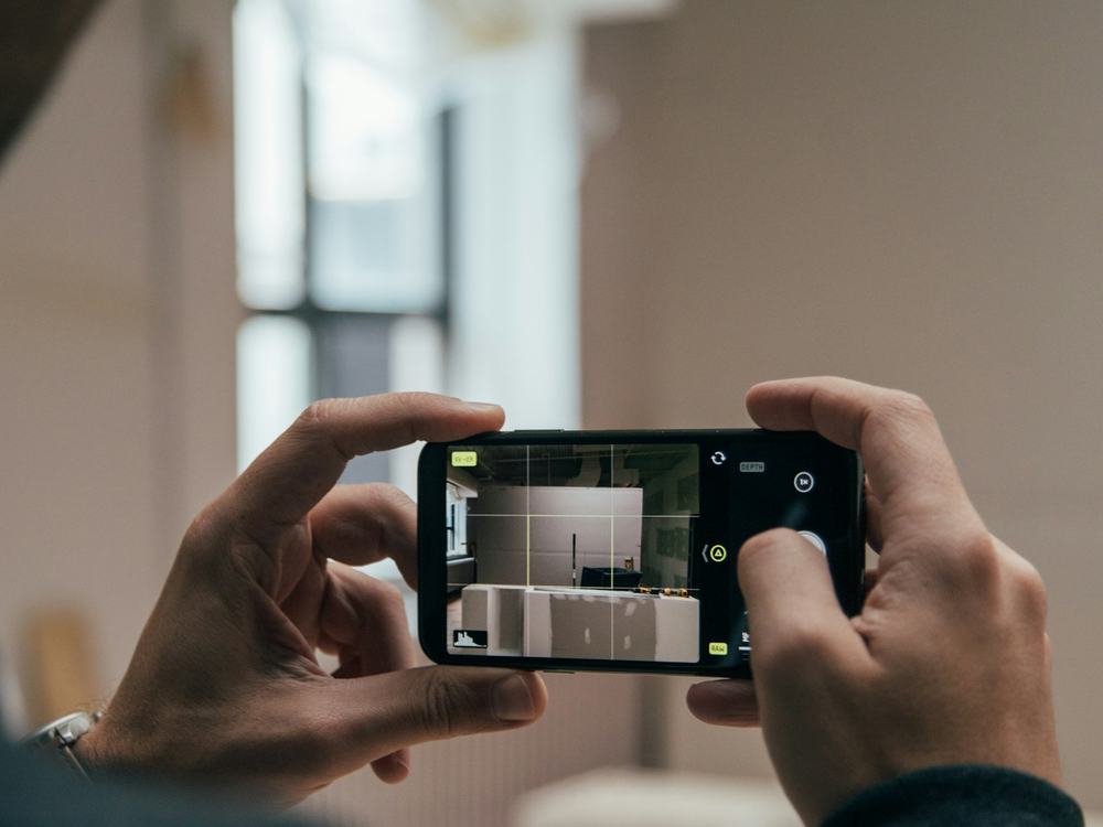 Person photographing a space on a smartphone