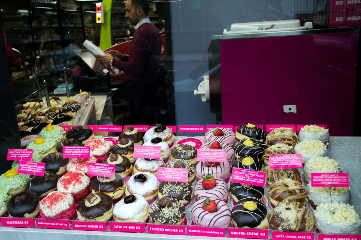 Bakery display case of decorated donuts and cakes